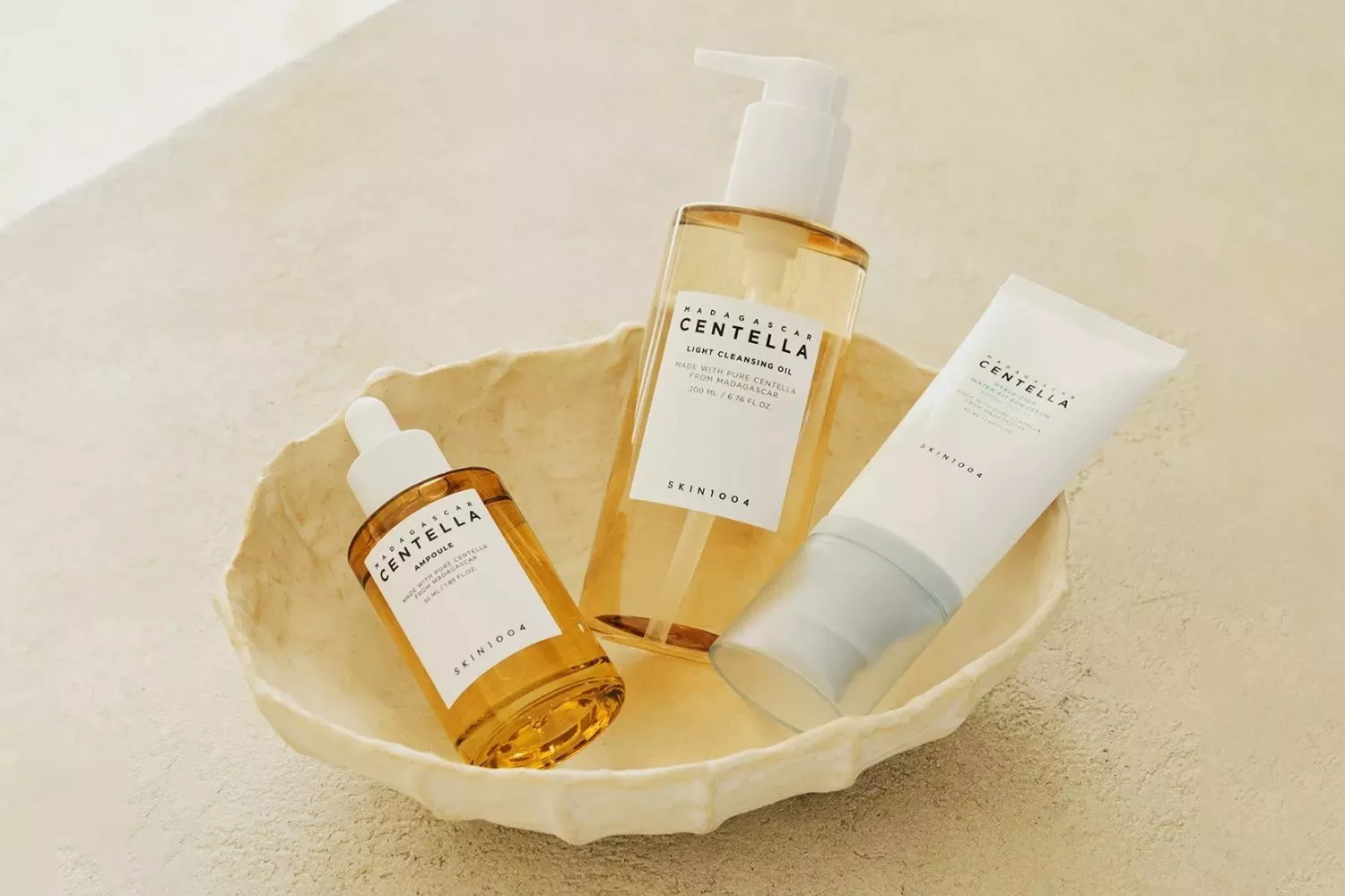 SKIN1004 Madagascar Centella skincare set with cleansing oil, ampoule and cream displayed in a ceramic dish