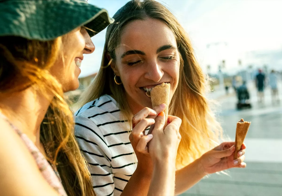 Person having a taste of their friends ice cream 