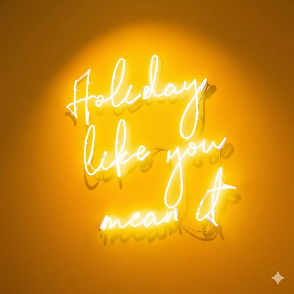 Neon yellow light sign spelling "holiday like you mean it"