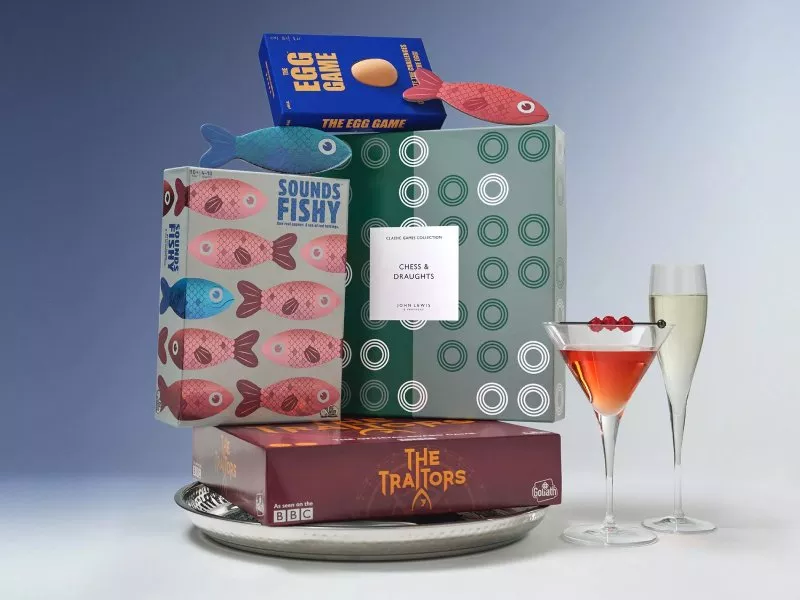 Image of a load of games stacked up on a silver plate with cocktails beside