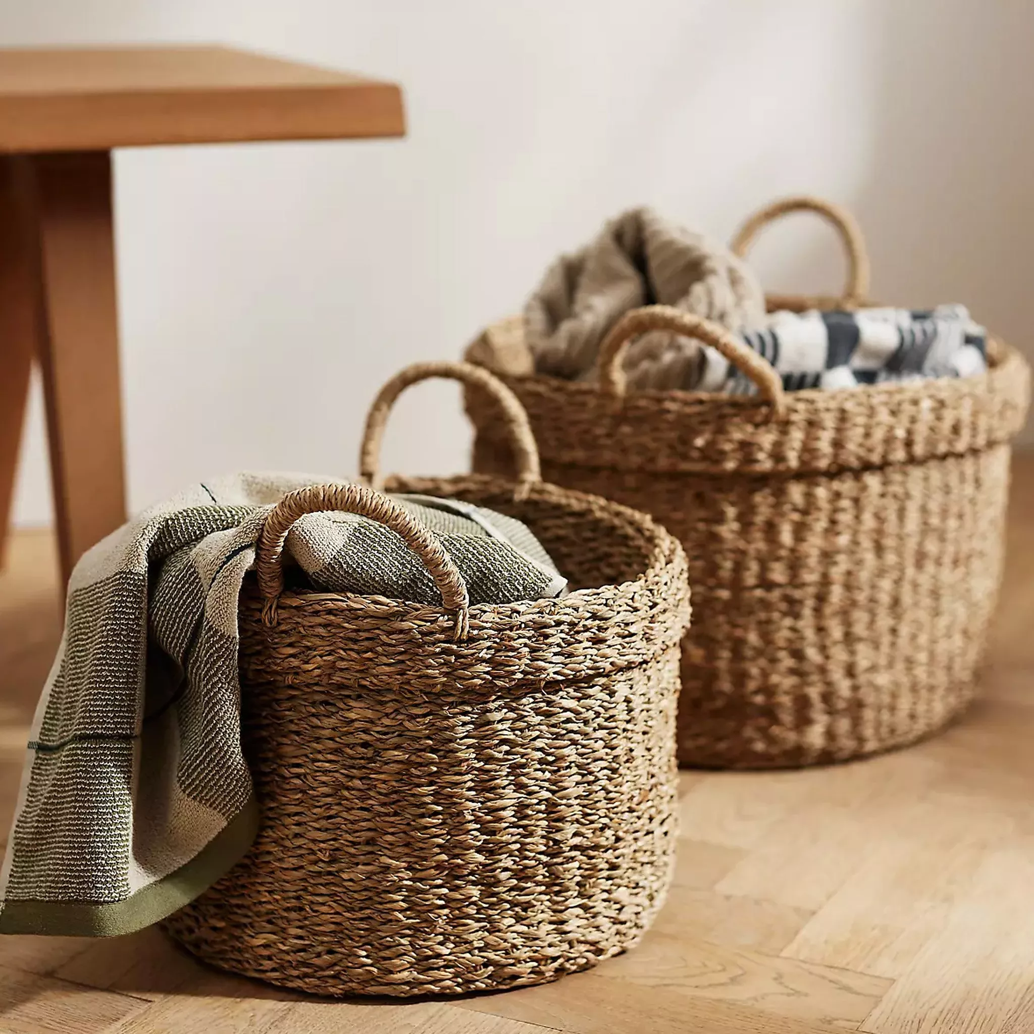 Rattan baskets holding towels on a wooden floor