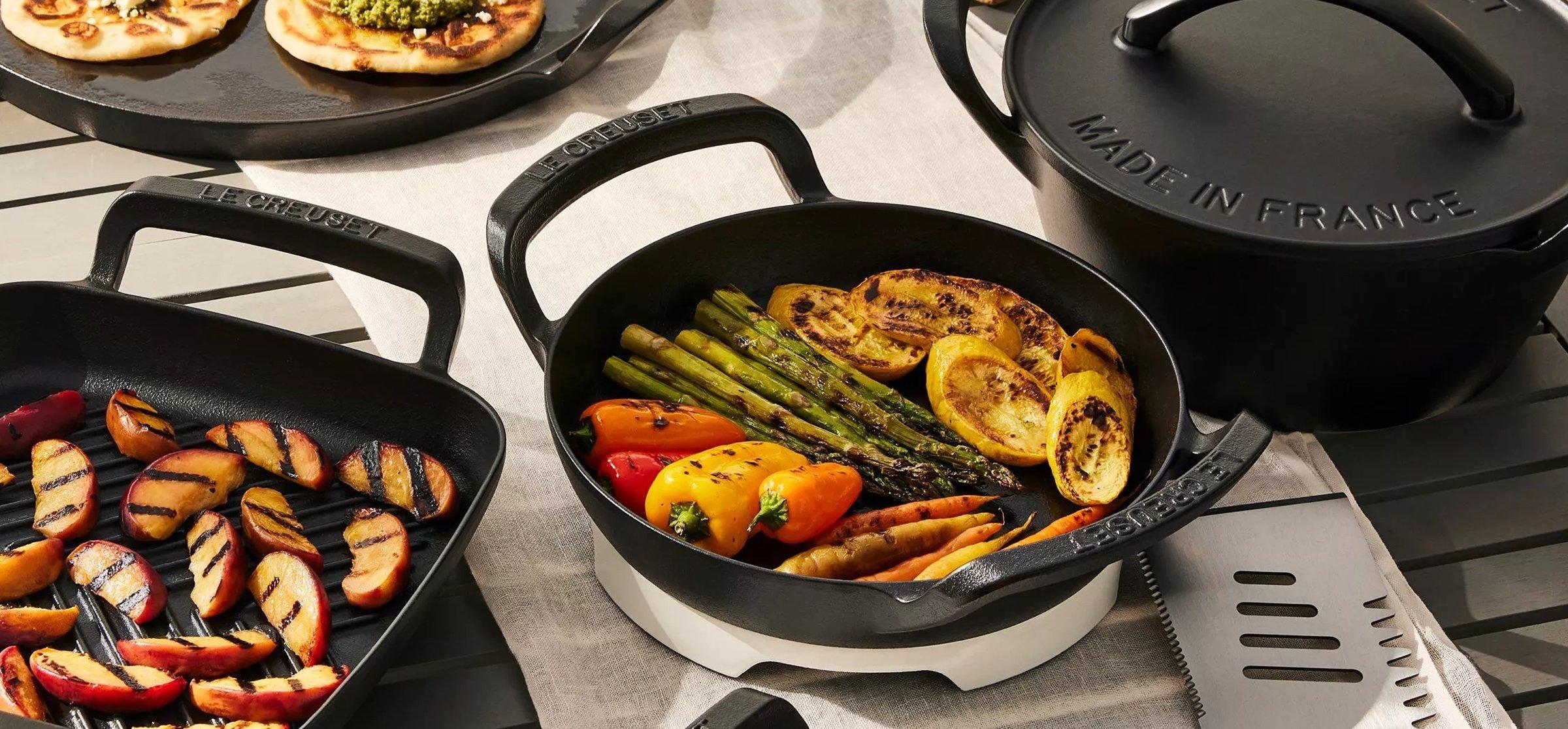 A collection of Le Creuset skillets on a table
