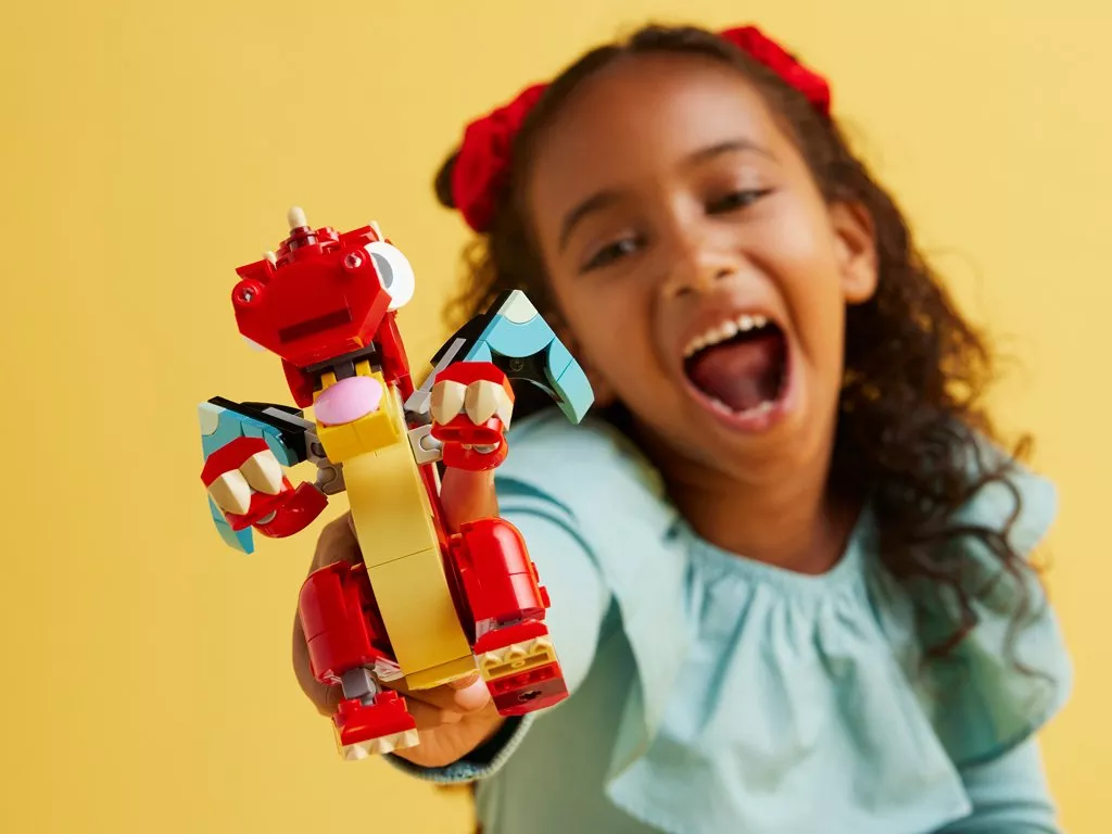 girl playing with a dragon lego set