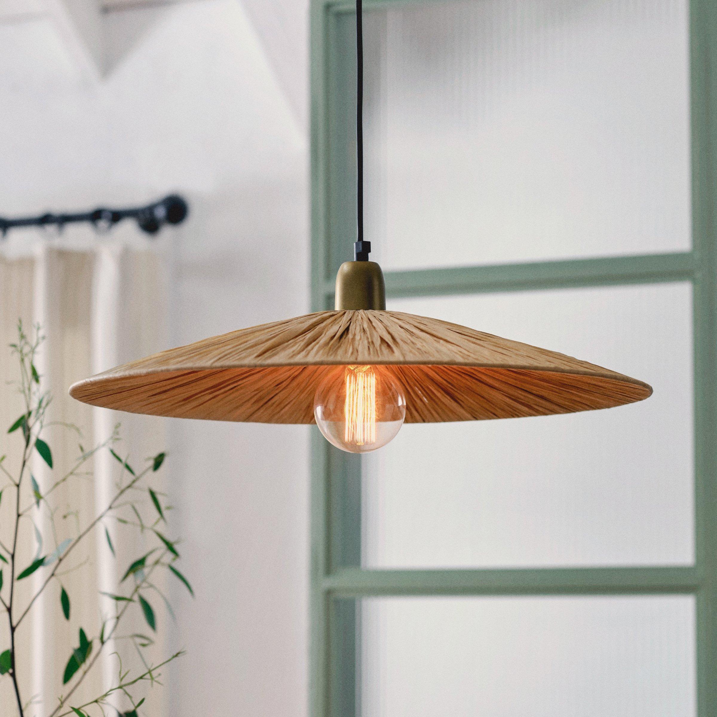 close up of a light with a straw lampshade and an exposed quirky bulb
