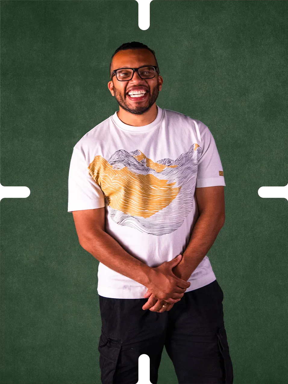 Peter Dyer in a mountain print T-shirt against a green background