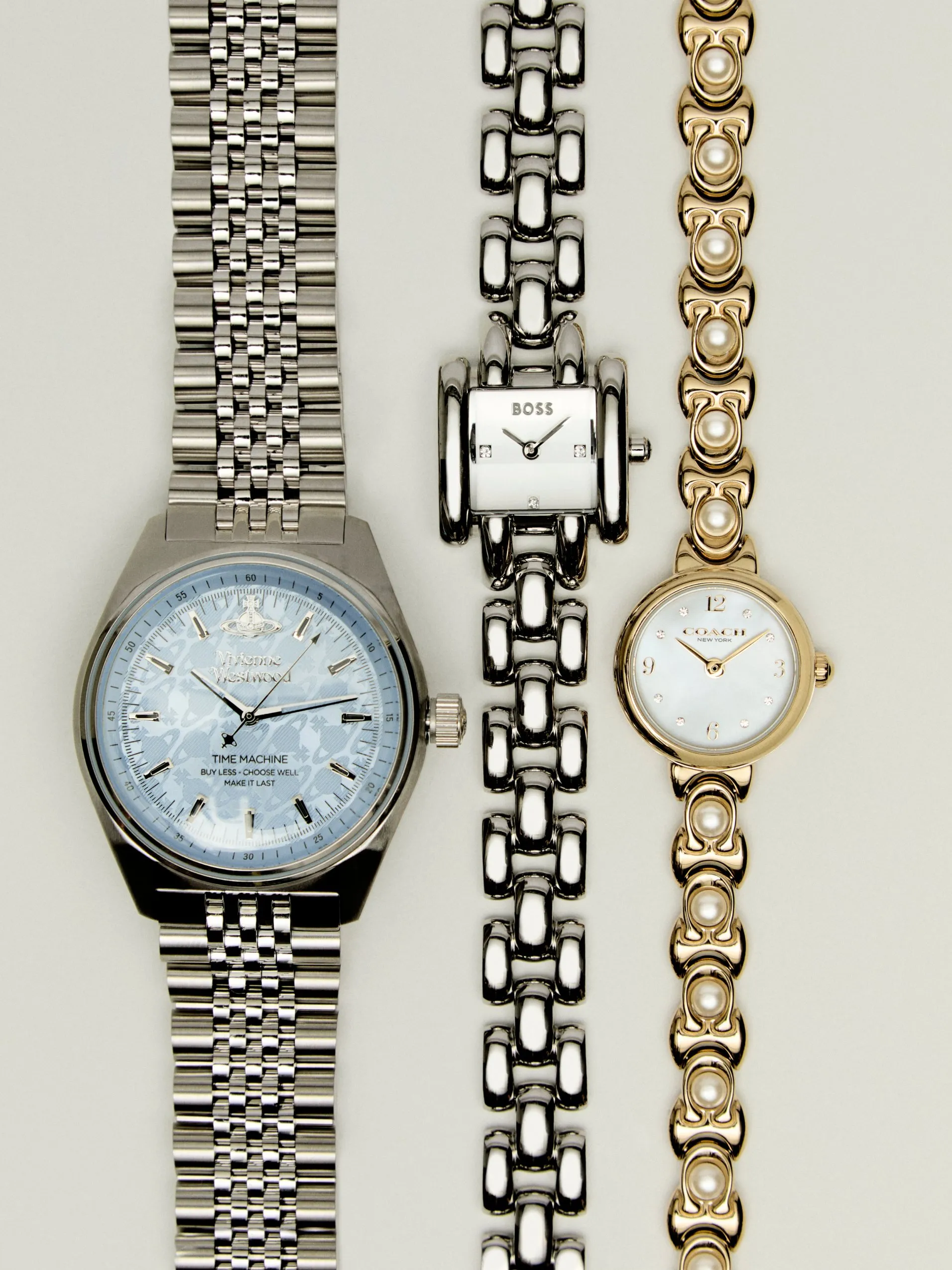 Three luxury wristwatches with metal bracelets, including pearl-accented gold watch, on a light background
