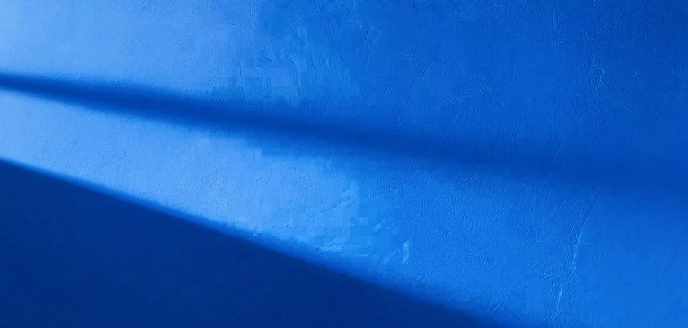 Blue wall with sunlight reflecting on it 