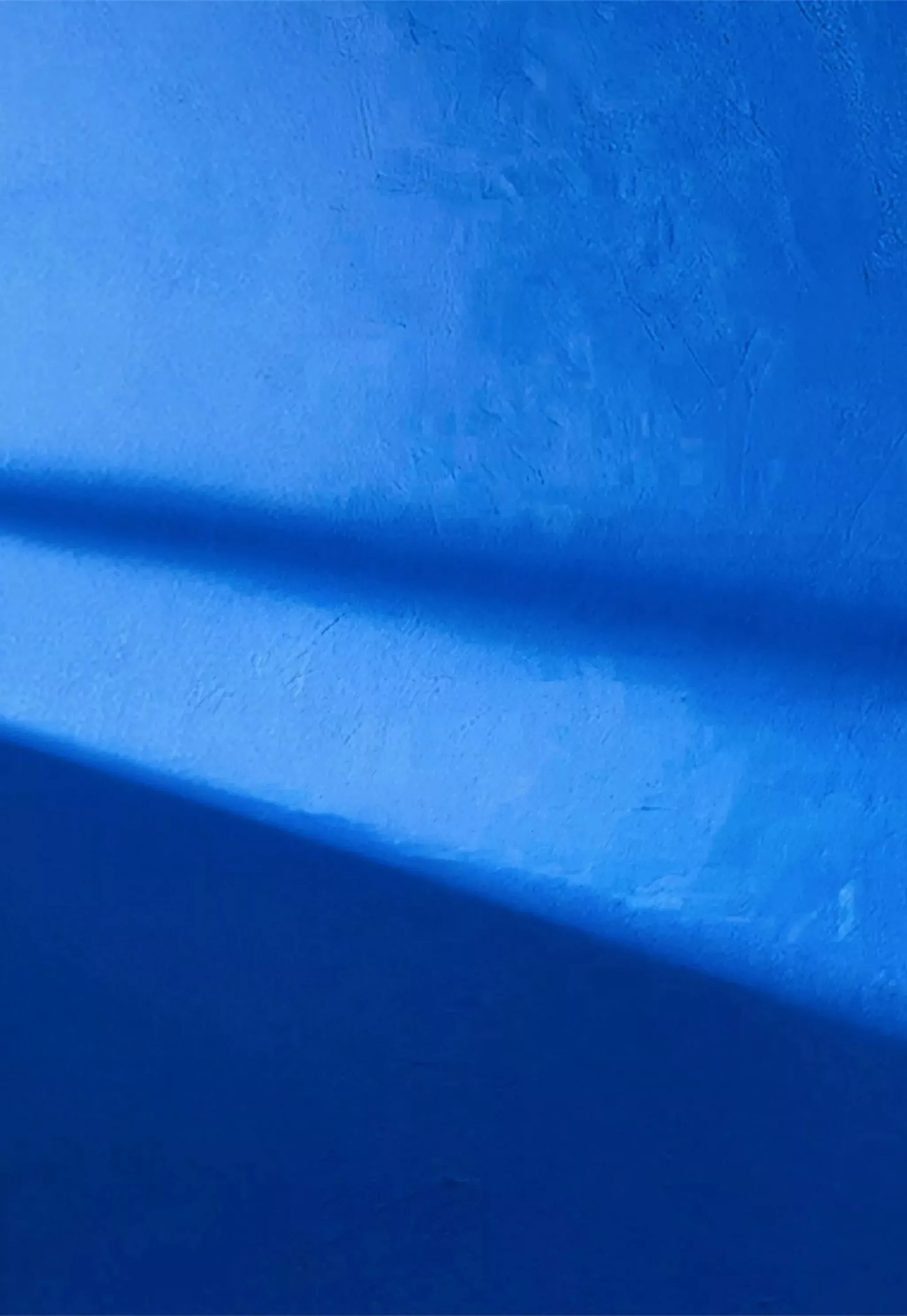 Blue wall with sunlight reflecting on it 
