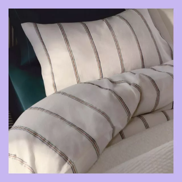 Close-up of white striped cotton duvet cover and pillowcase on bed, soft neutral bedding for bedroom decor