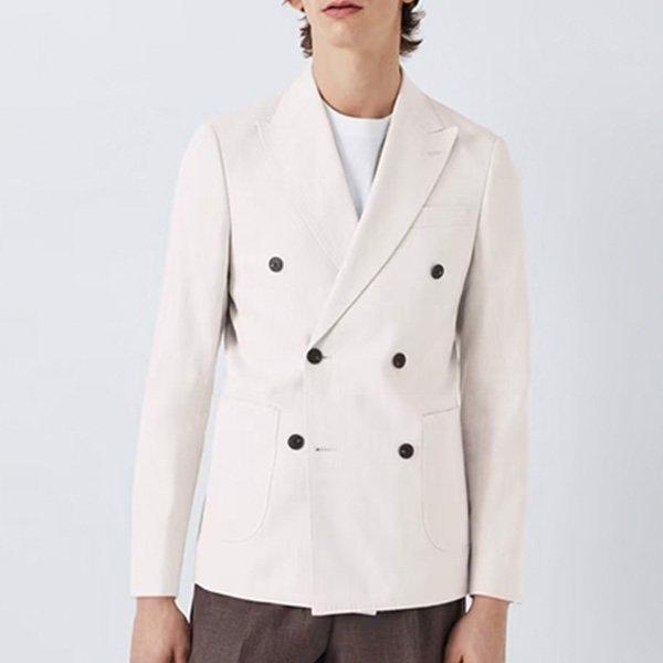 A close-up shot of a man wearing a casual, white double-breasted blazer.