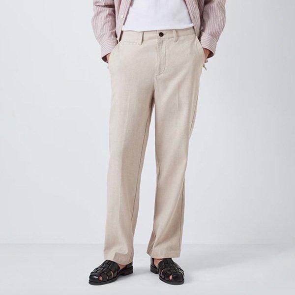 A person wearing beige trousers and black sandals.
