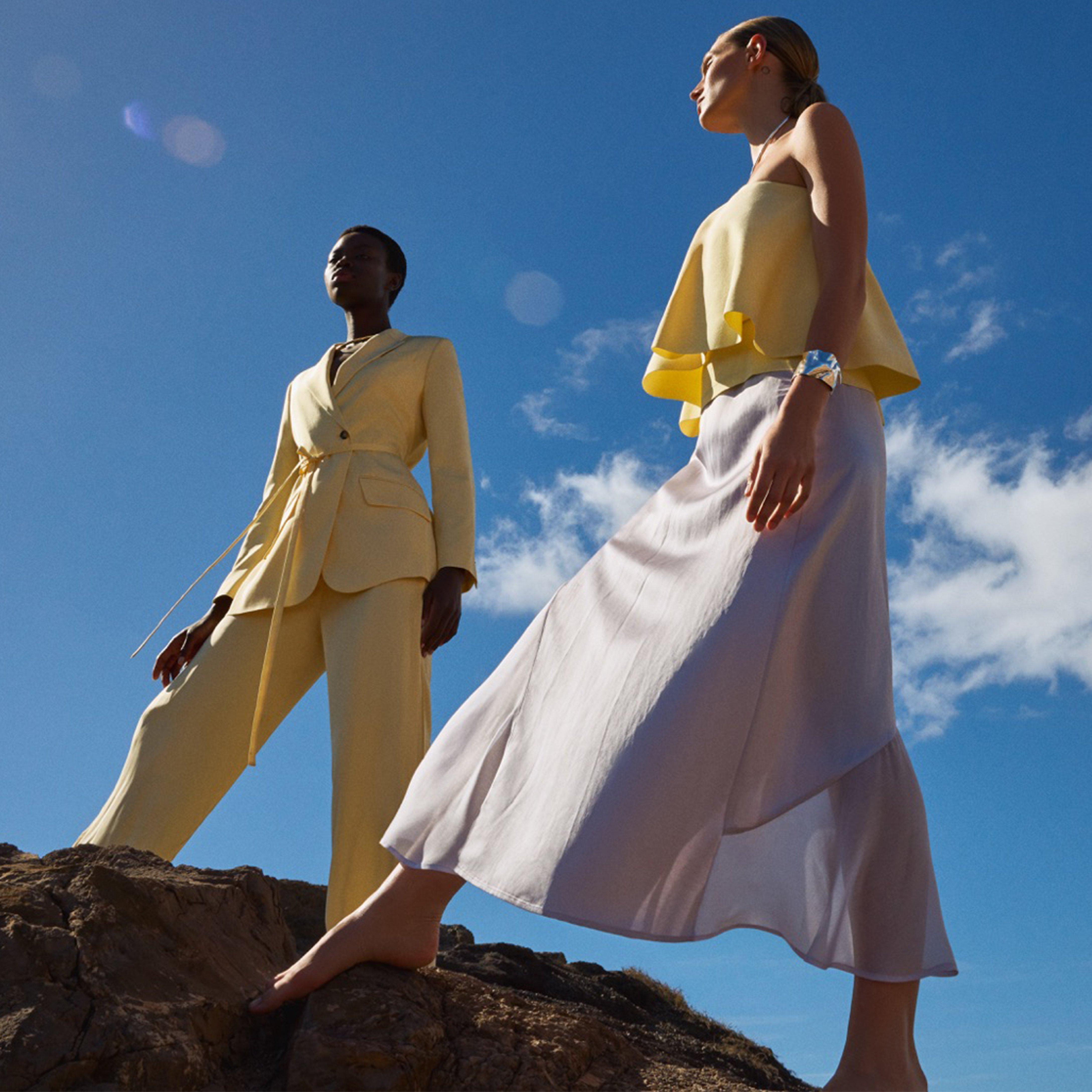 Women in evening dresses standing on rocks
