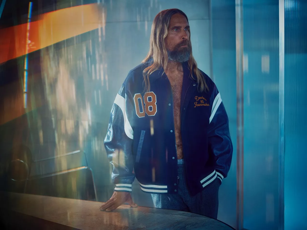 Male model wearing a navy varsity jacket