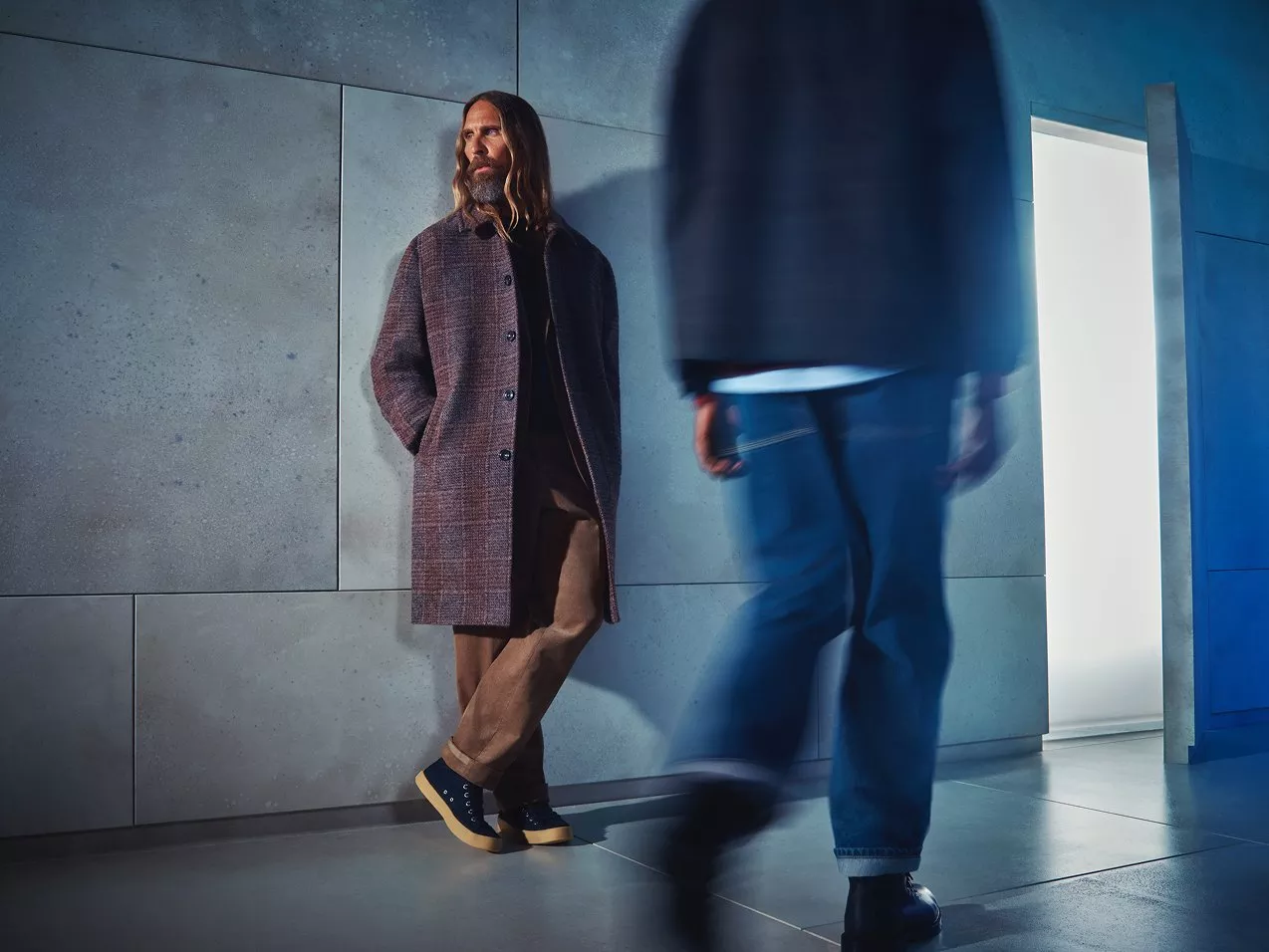 Male model wearing a long checkered winter coat