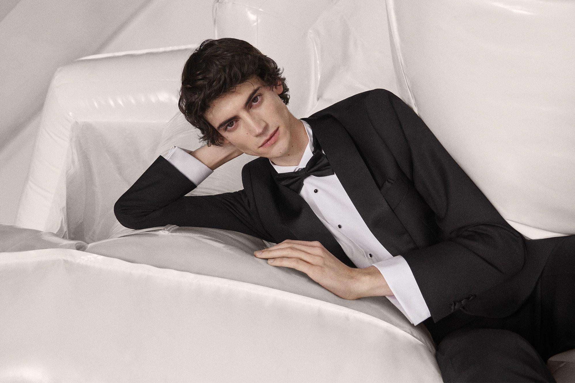 Image of a groom in a black cocktail suit with a bow tie