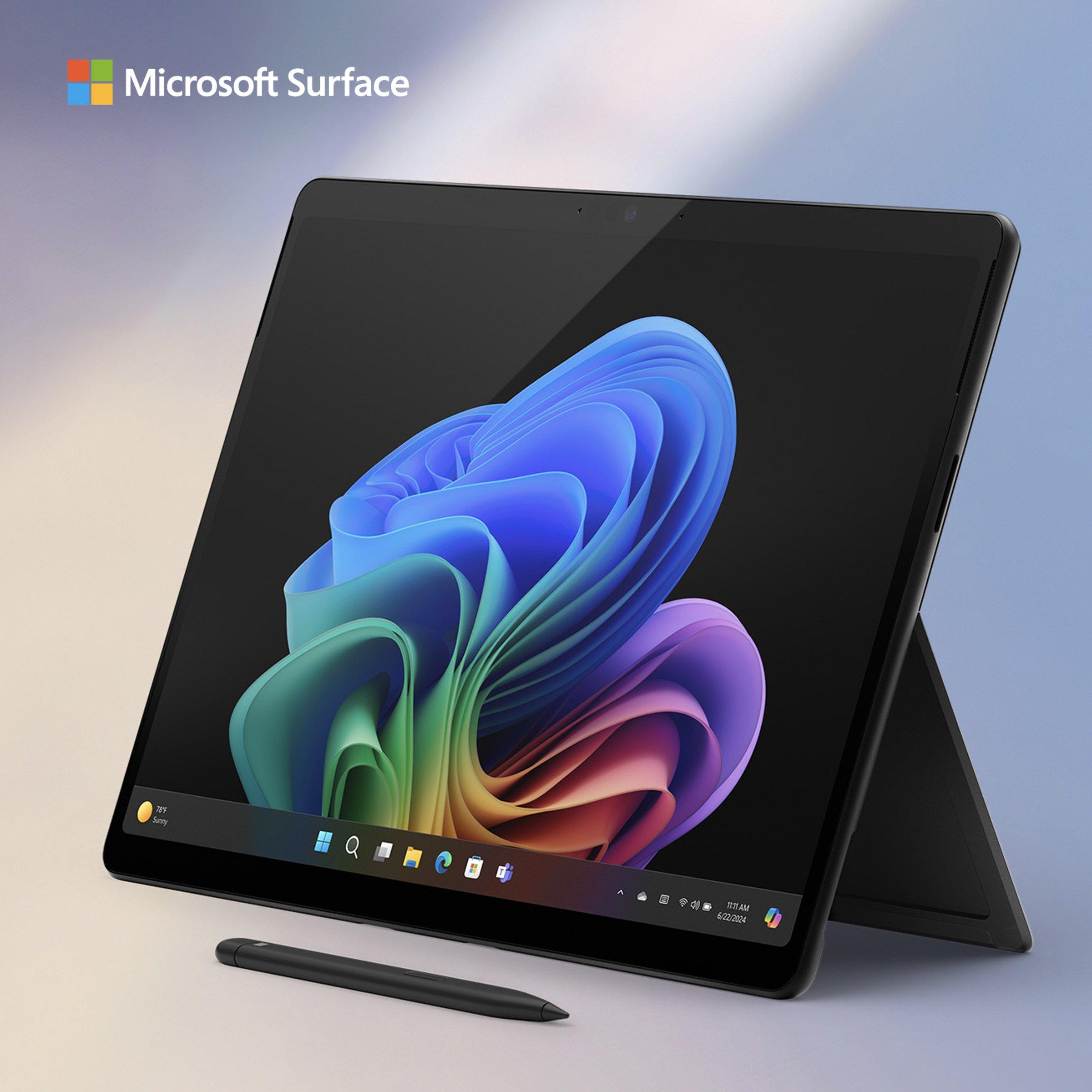 microsoft surface sleek, black tablet-style pc with vivid and colorful abstract wallpaper and a pen lying in front of the device.