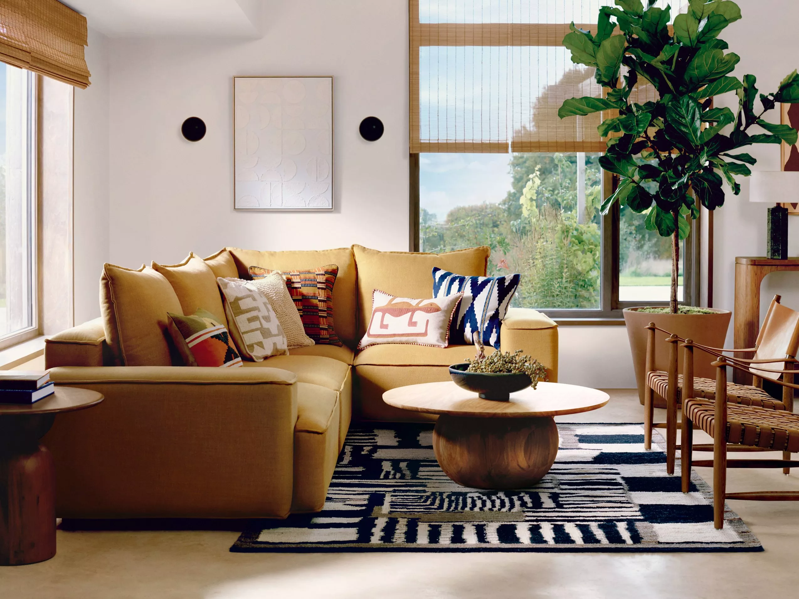 Cosy bedroom with a soft headboard, blue pillows, and patterned cushions on a neatly made bed.