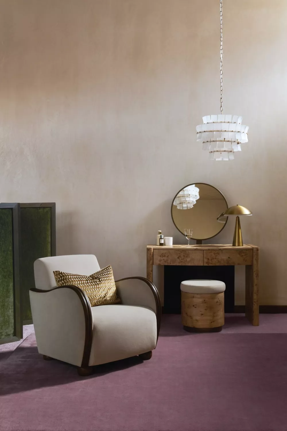 Modern lounge corner with upholstered armchair, walnut vanity table, round mirror and pendant light on mauve carpet