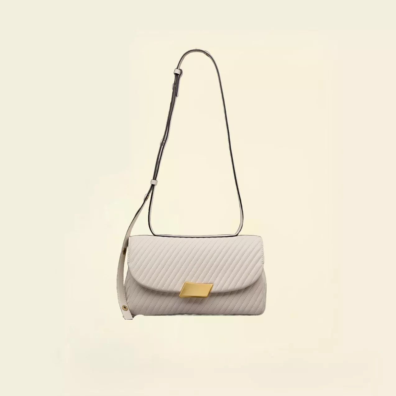 Beige quilted handbag with strap, set against a vibrant, colourful abstract background.