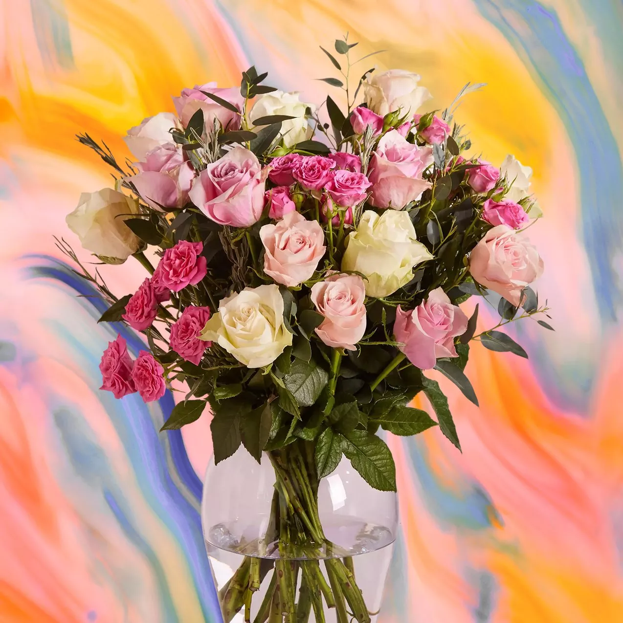 A bouquet of pink and white roses in a clear vase against a vibrant, swirling multicoloured background.