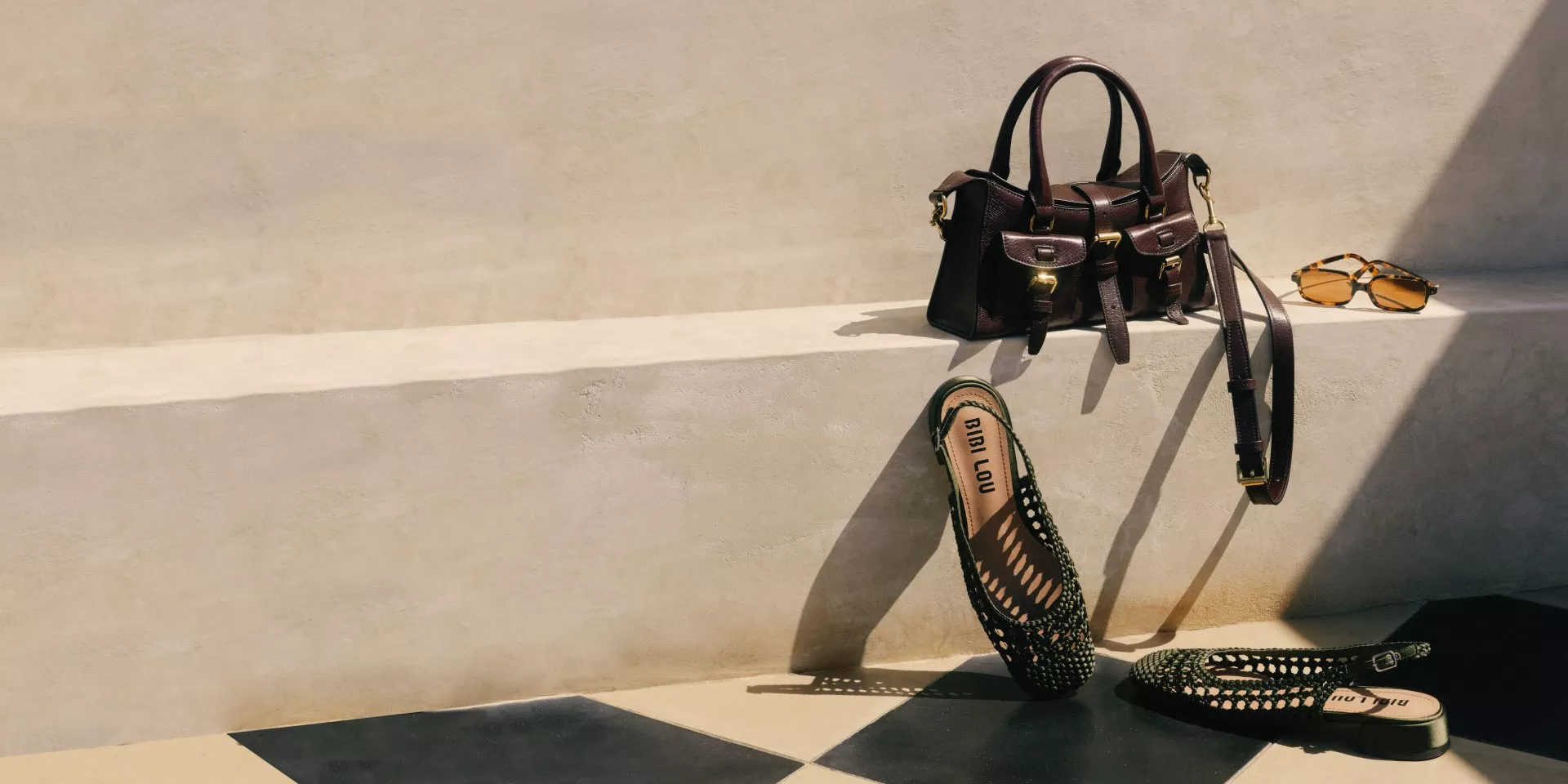 Luxury leather handbag, tortoiseshell sunglasses and woven flats on sunlit stone steps, fashion still life