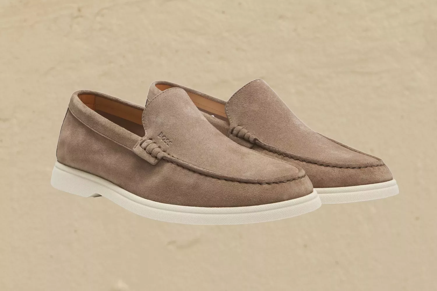 Men’s brown leather penny loafer with stitched apron toe and gum sole, side view on neutral background