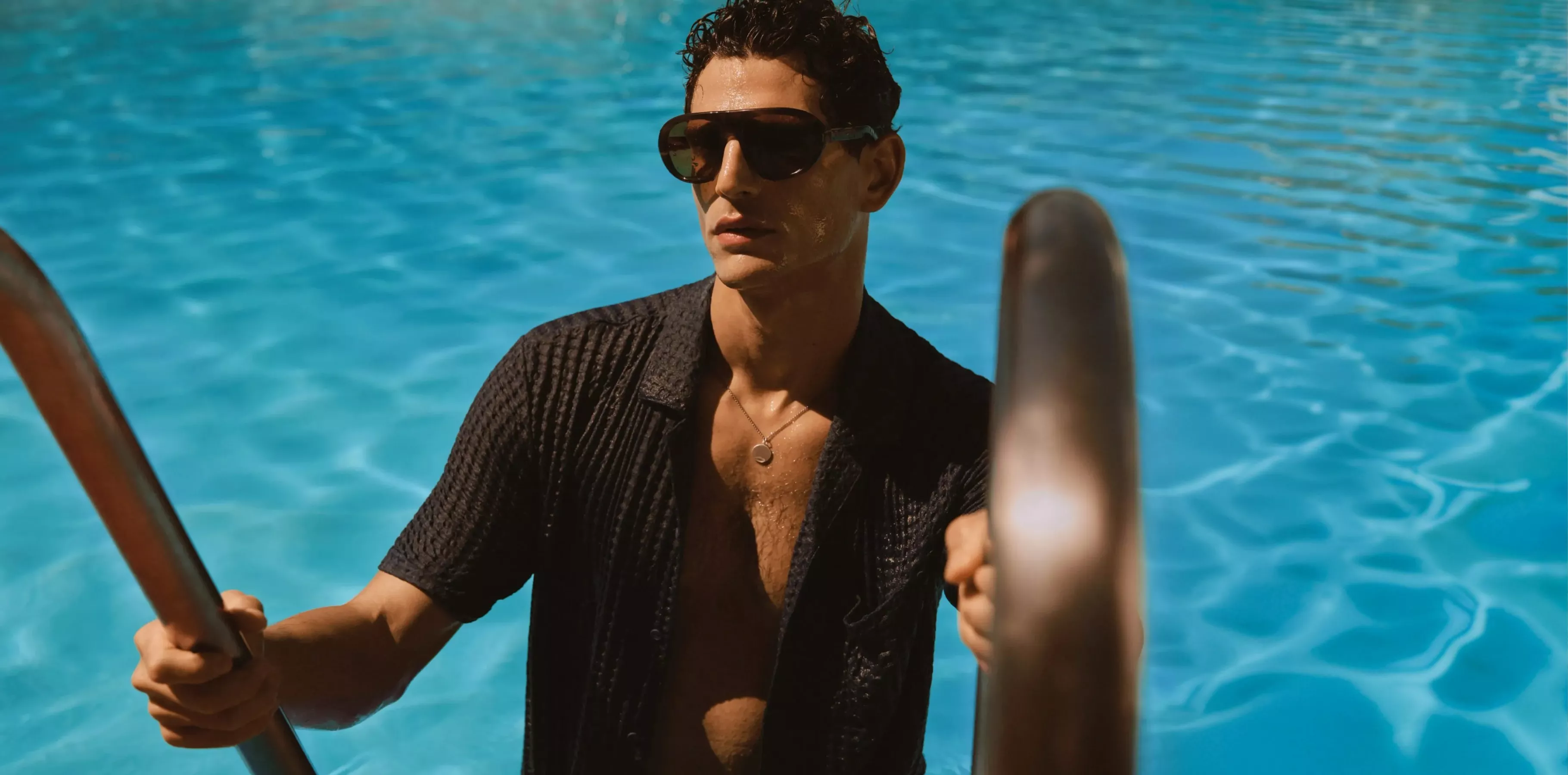 man coming out of a swimming pool with a short sleeve shirt
