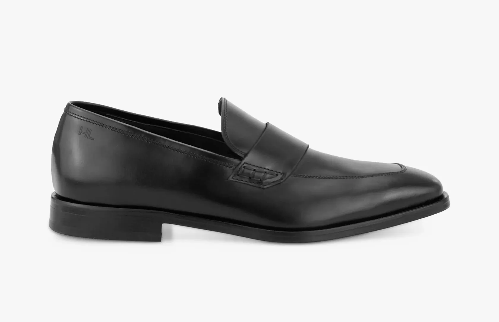 Black leather penny loafer dress shoe, side view on white background, classic slip-on formal footwear