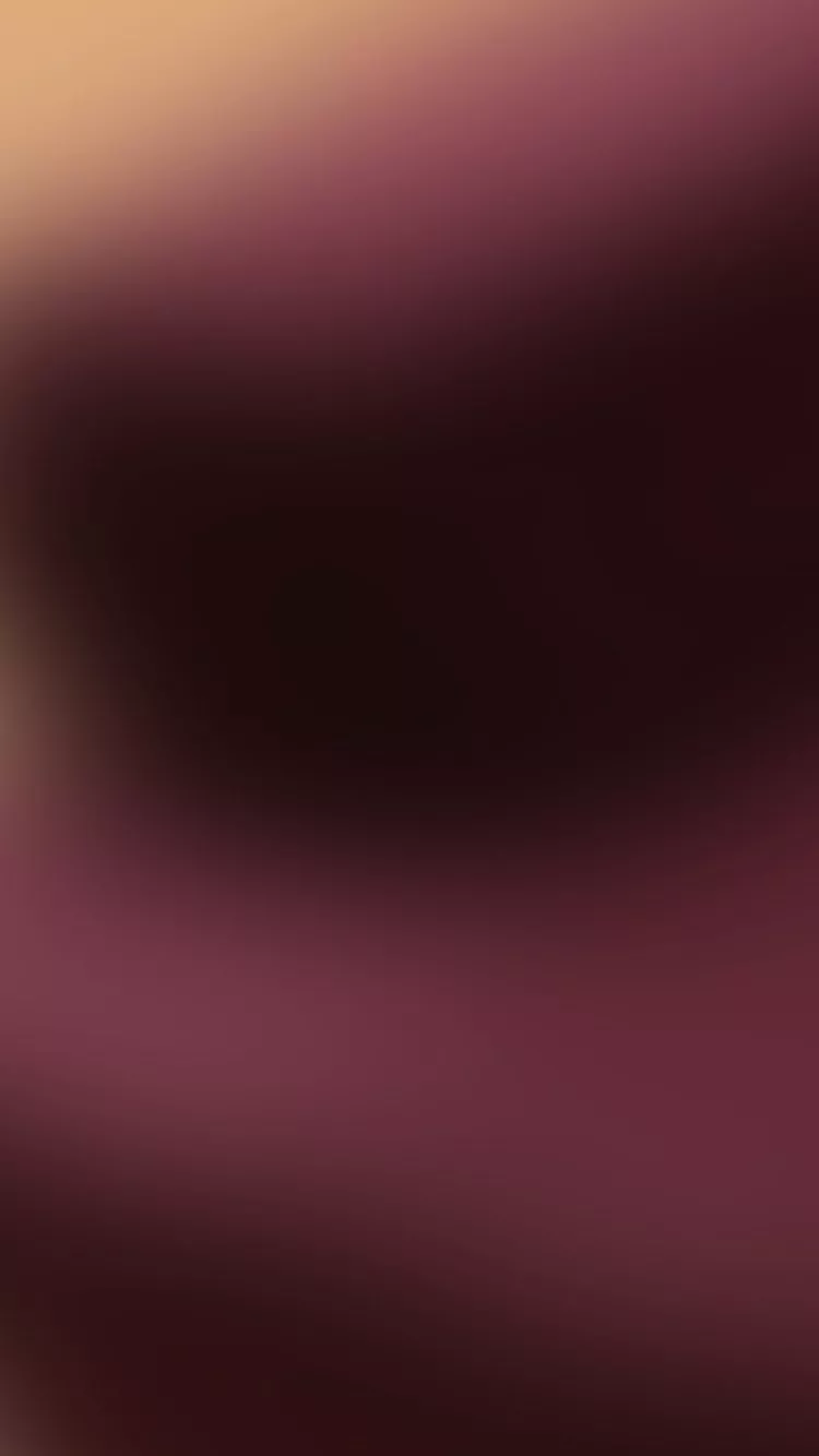 Abstract, blurred background of dark maroon, brown, and a light peach tone.
