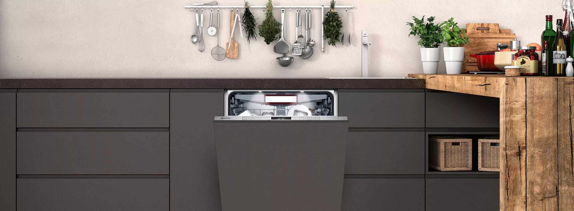 Modern kitchen with integrated dishwasher, hanging utensils, herb plants and rustic wooden worktop styling.