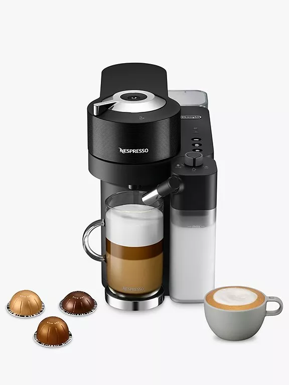 Vertuo Lattissima machine with a milky coffee and capsules scattered next to it 