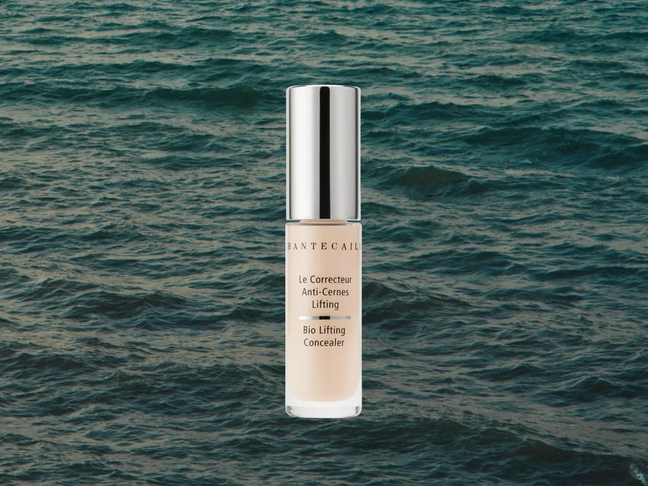 Chantecaille Bio Lifting Concealer bottle with silver cap centred over textured ocean water background