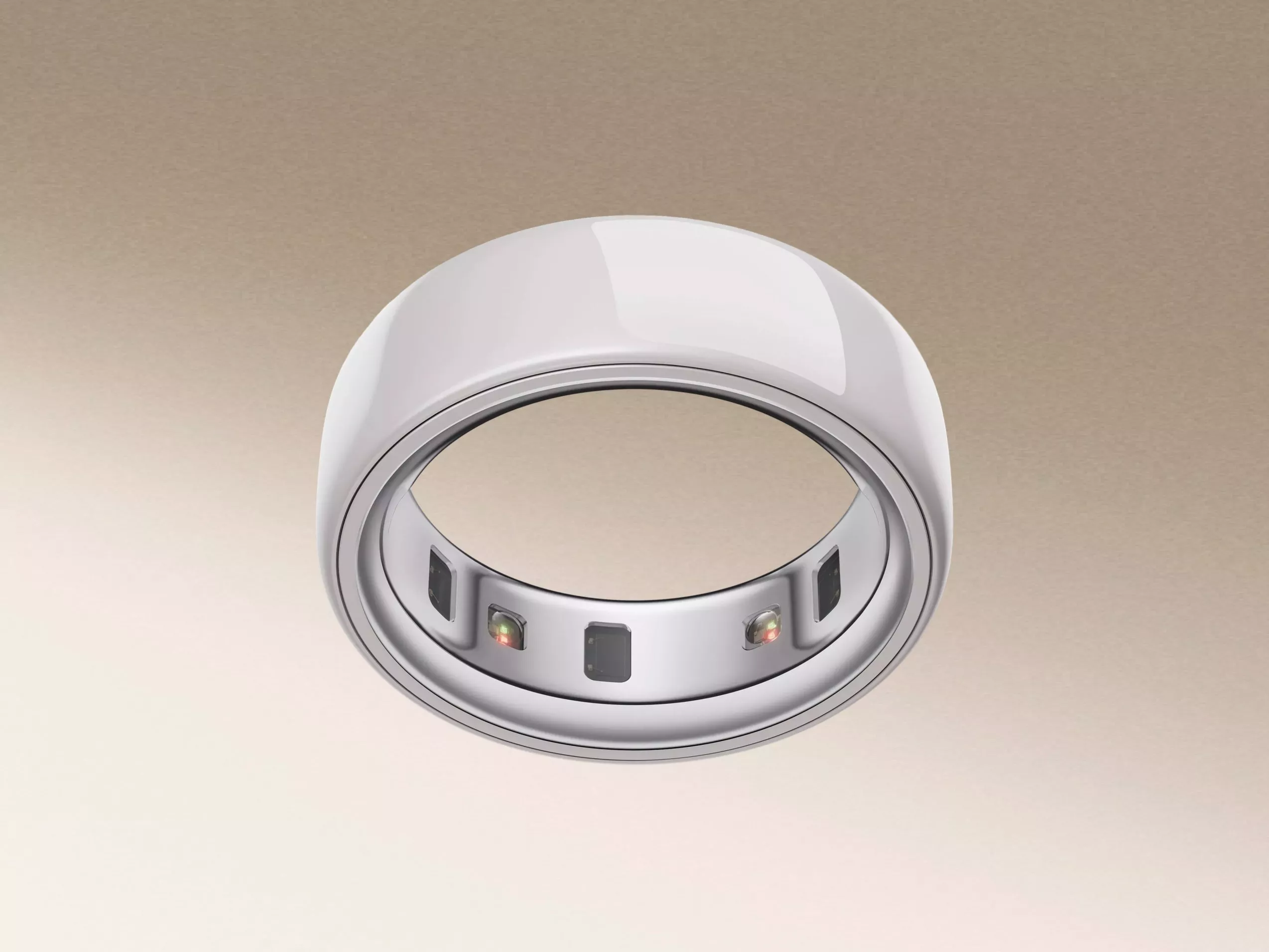 A sleek, modern smart ring with embedded sensors on the inner surface, set against a neutral gradient background.