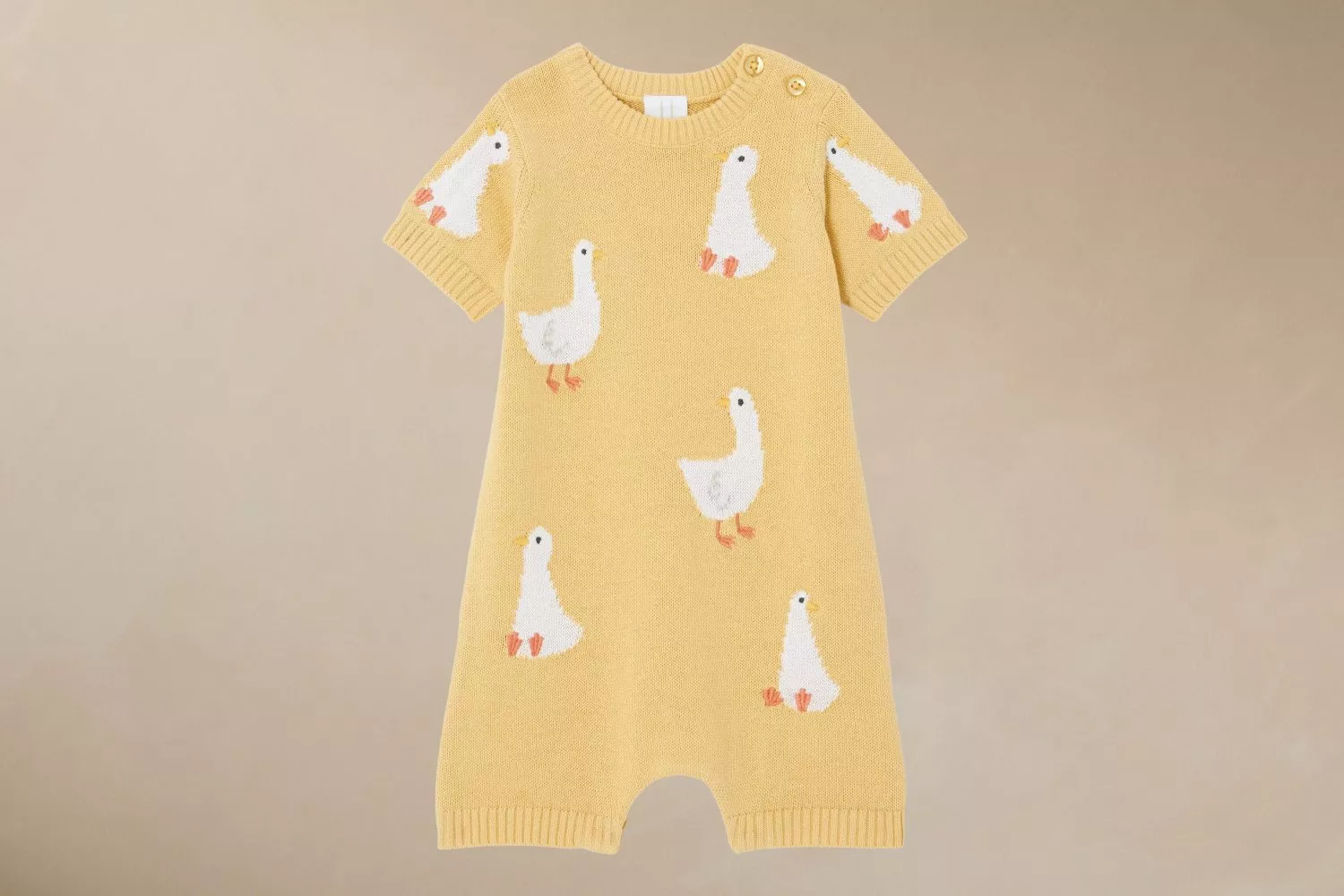 Yellow baby romper adorned with cute white duck motifs, featuring short sleeves and button details on the shoulder.