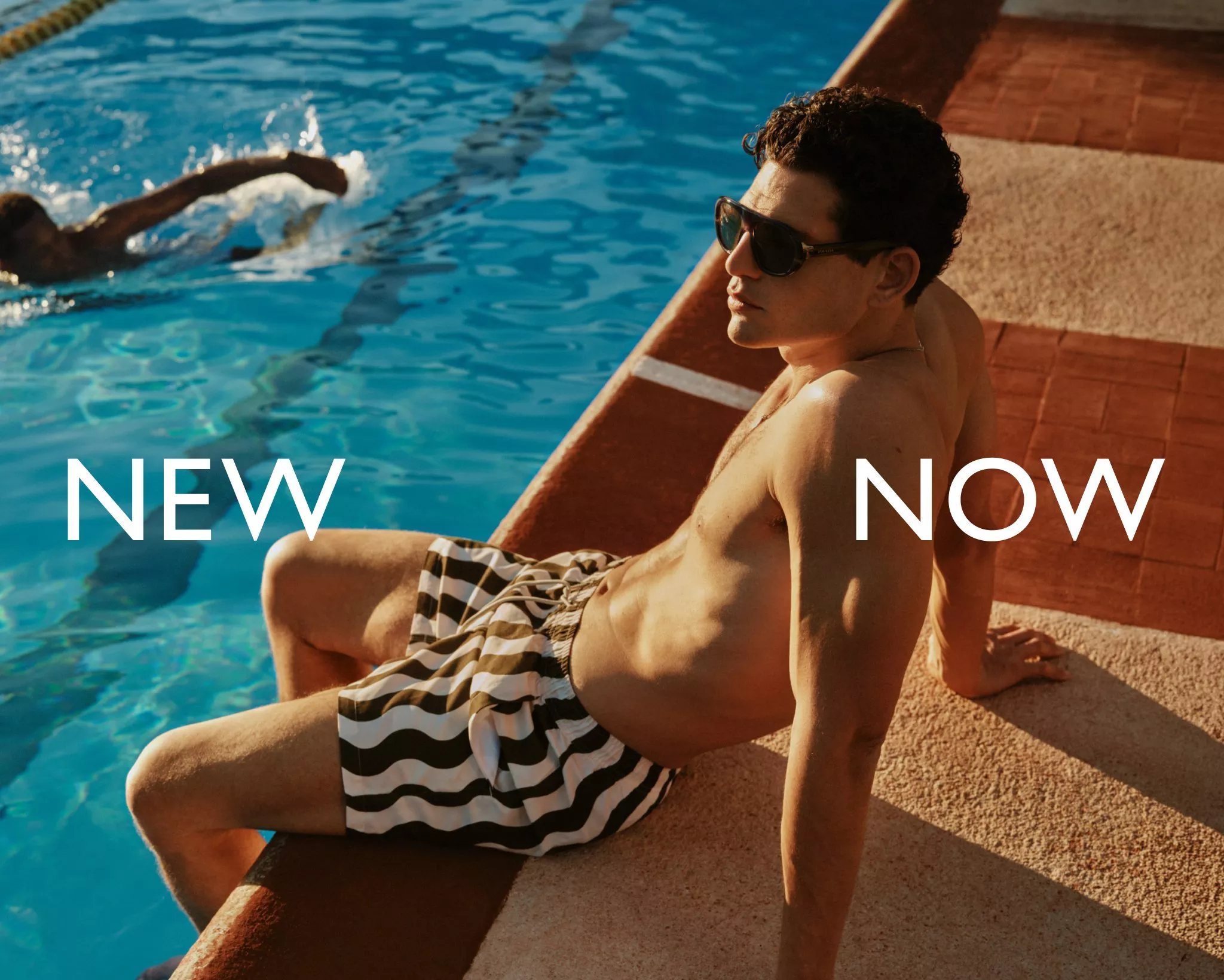 man wearing stripy shorts sitting on the edge of a pool with words NEW NOW on the image