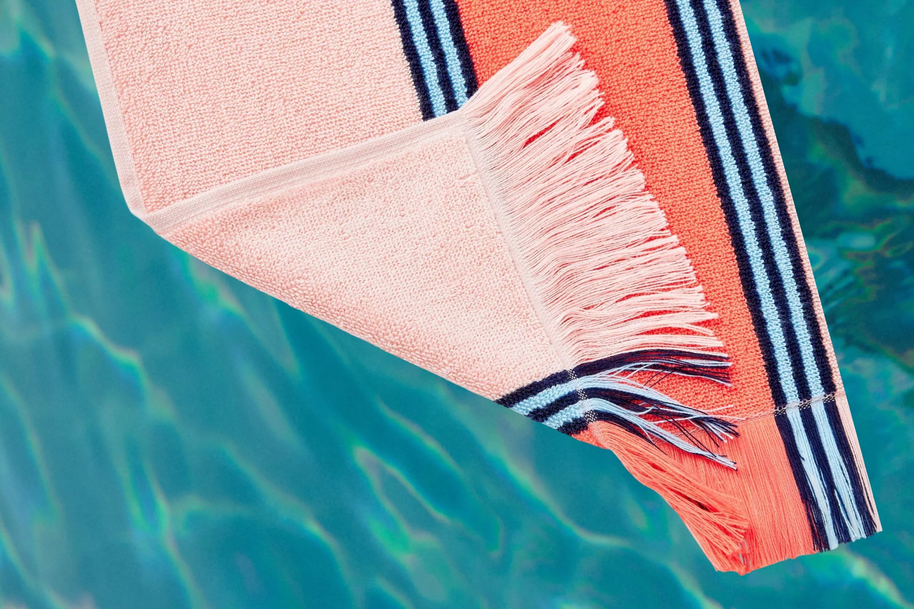 John Lewis Stripe Terry Beach Towel cutout on a pool background