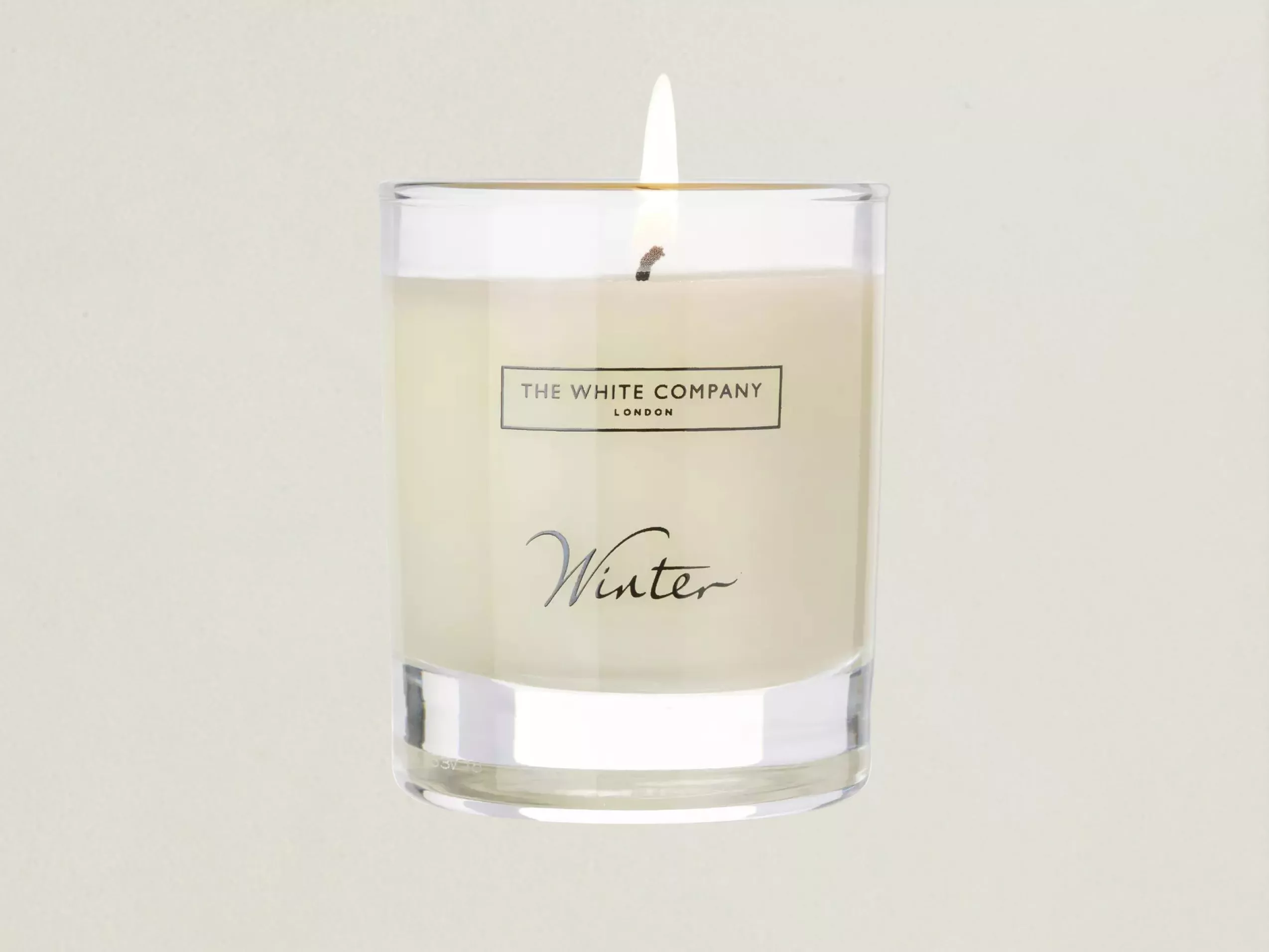 Lit The White Company London Winter scented candle in clear glass jar, cosy home fragrance close-up