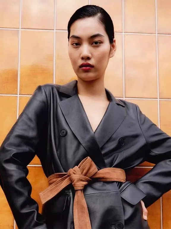 Image of a woman in a black leather blazer against terracotta tiles 