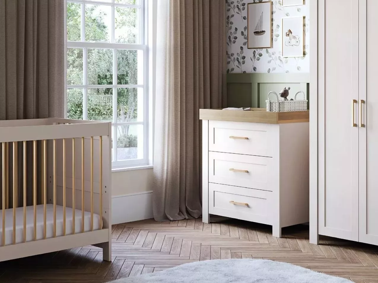Modern nursery with wooden cot, white changing unit and wardrobe, grey curtains and leafy wallpaper accents