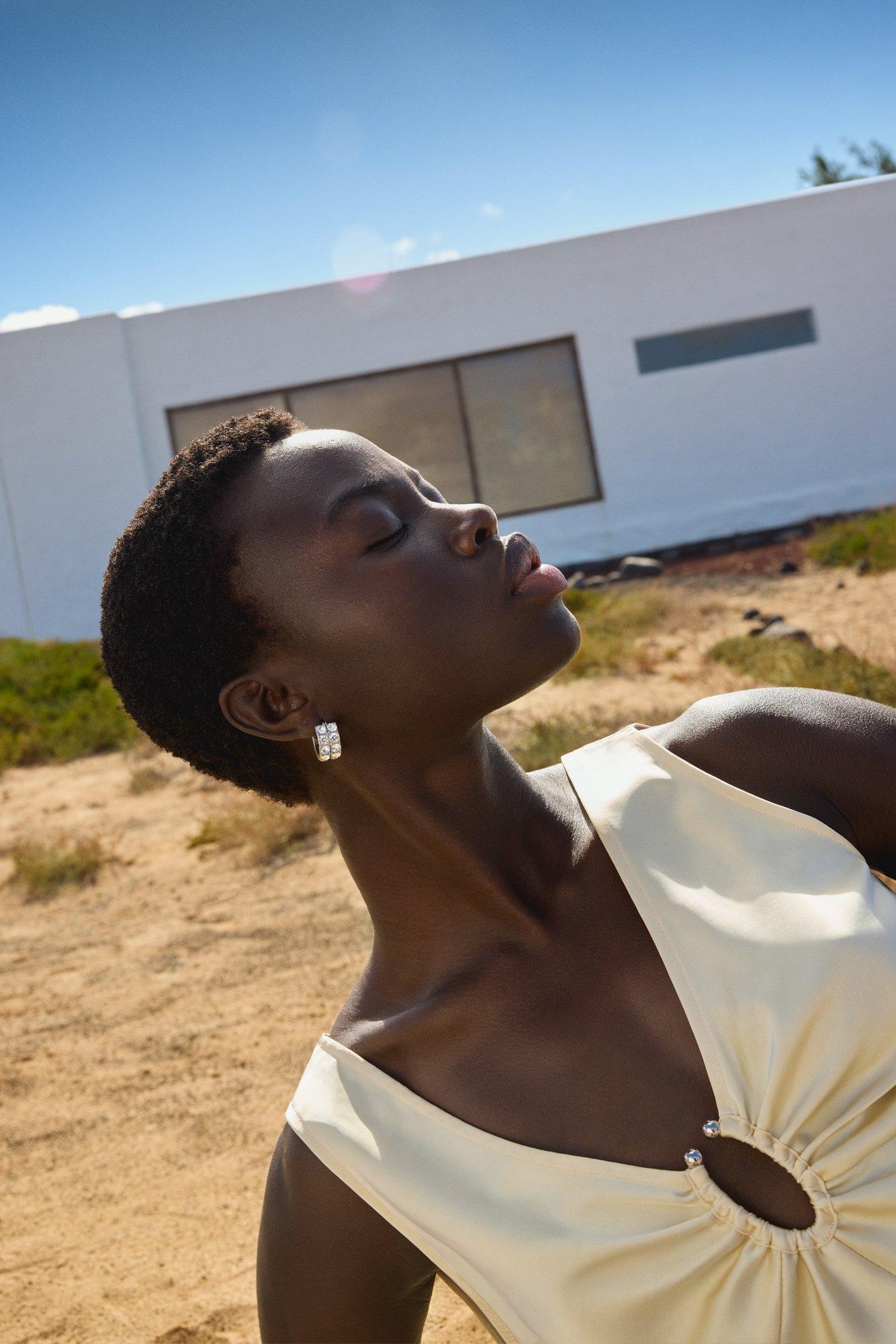 image of a women in a warm desert landscape holding her face up to the sun