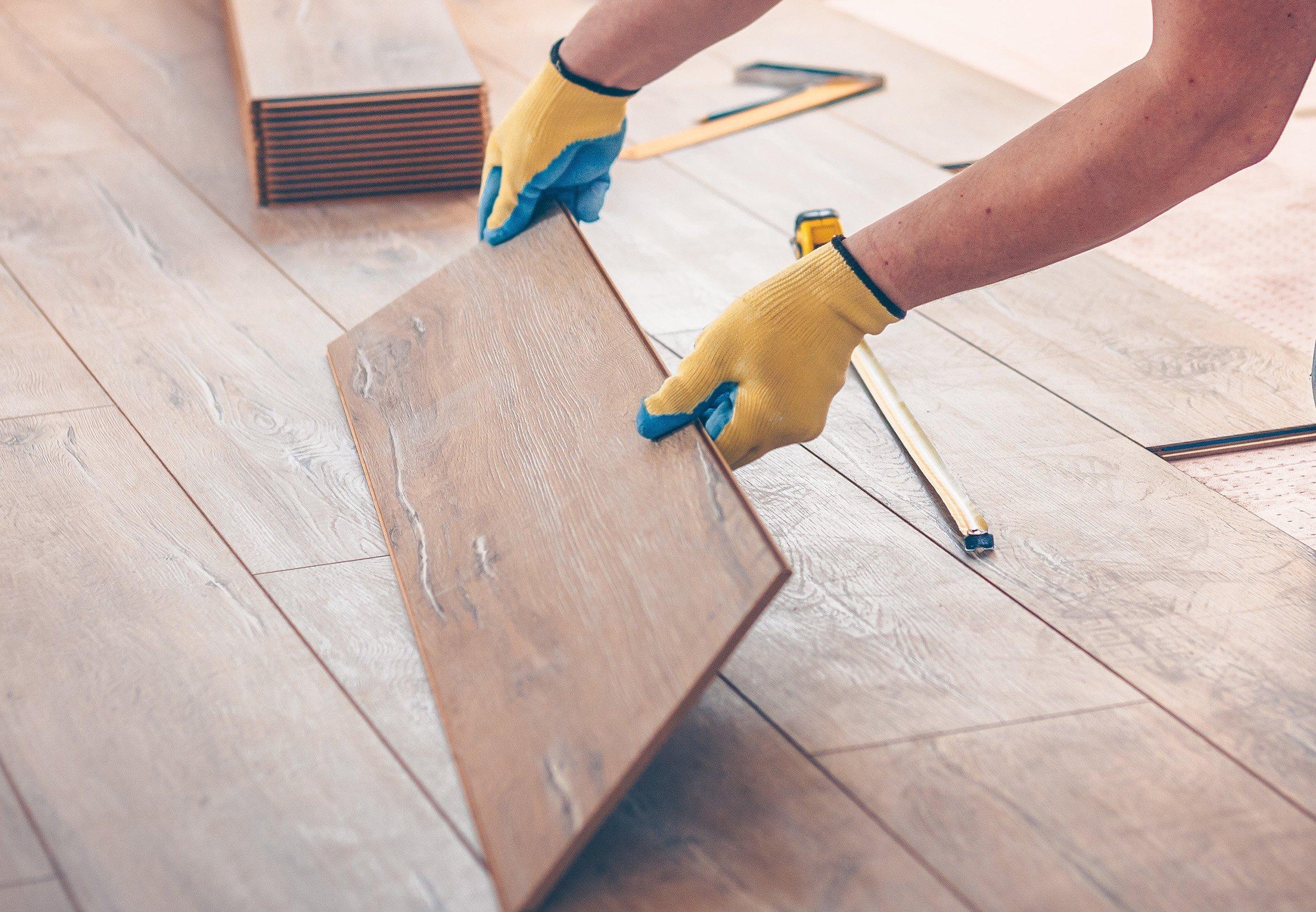 Person fitting a laminate board into a floor