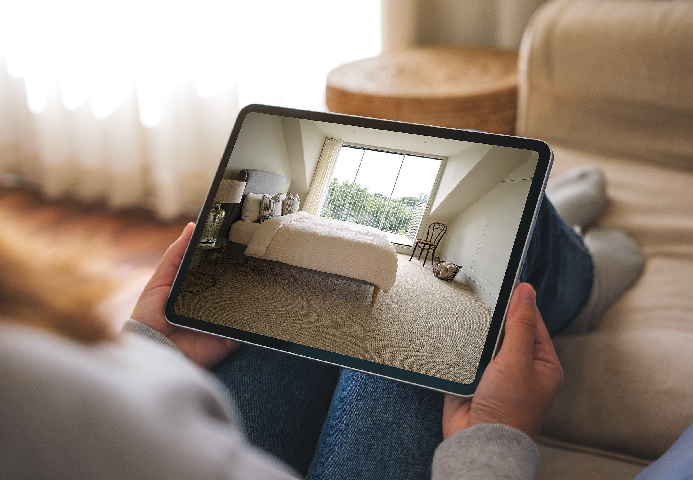 Person holding a tablet with an interior of bed window and floor on it