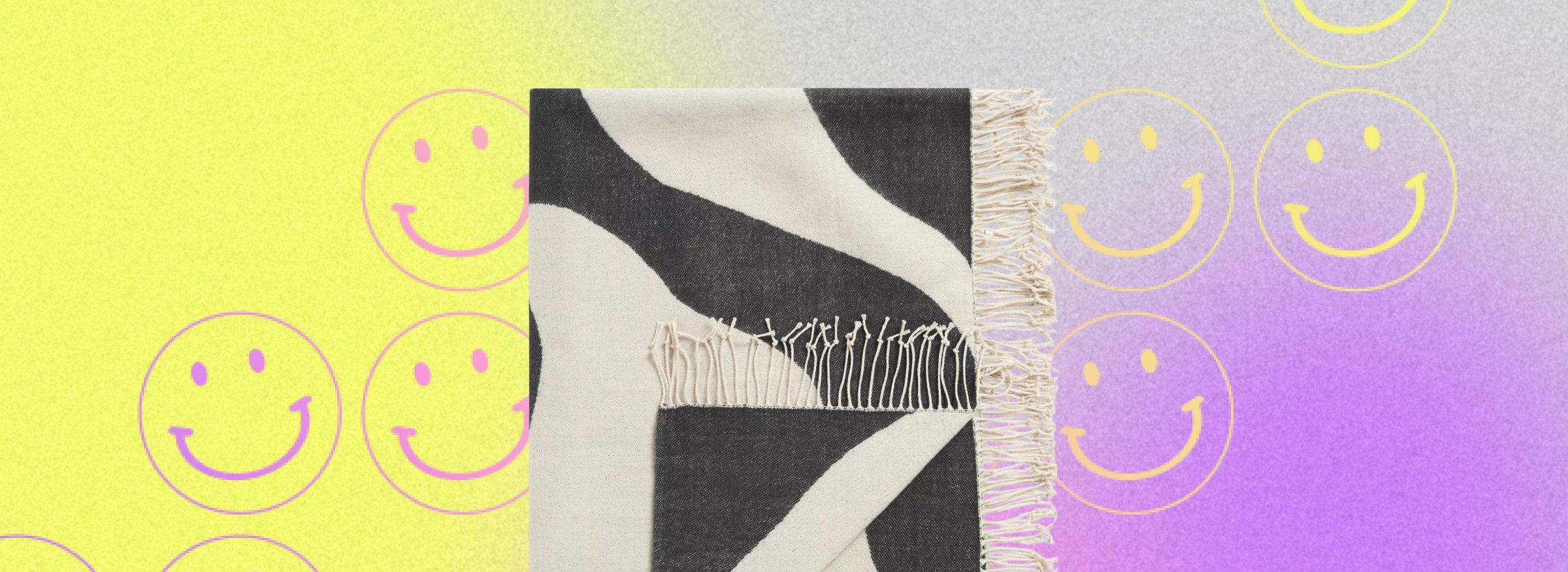 cutout of a towel on a multicolour bacground with smiley faces on it