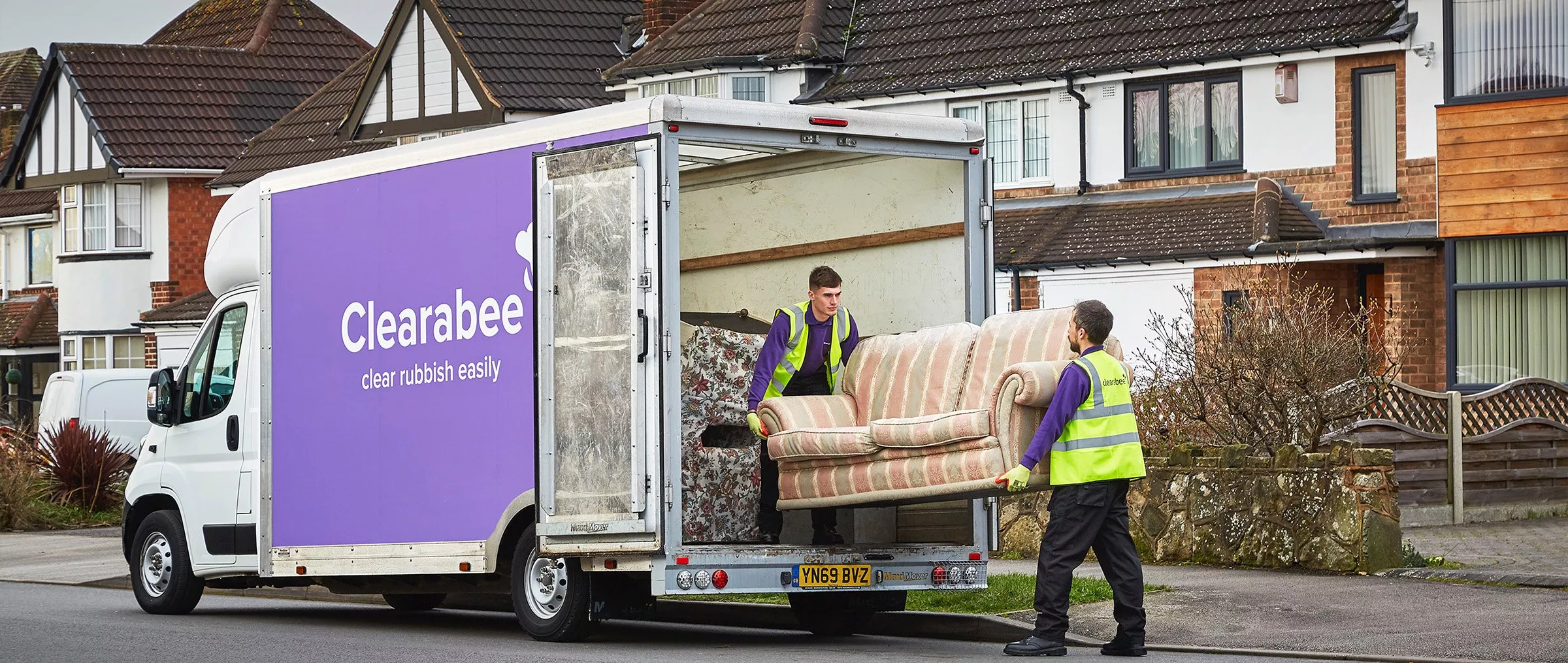 Grey sofa with cushions on and wooden coffee table