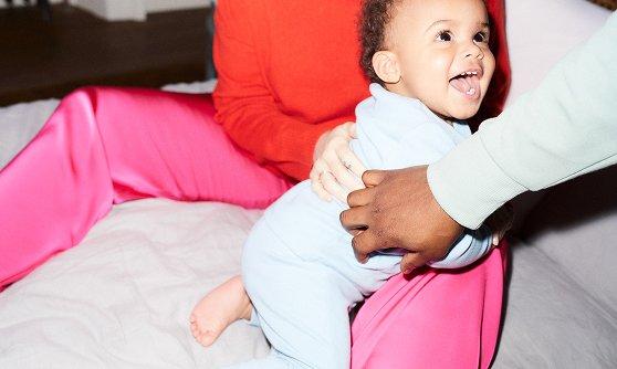 Smiling baby in the arms of their mother.