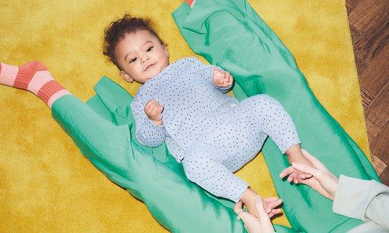 Baby lying on the floor inbetweens it's mothers legs