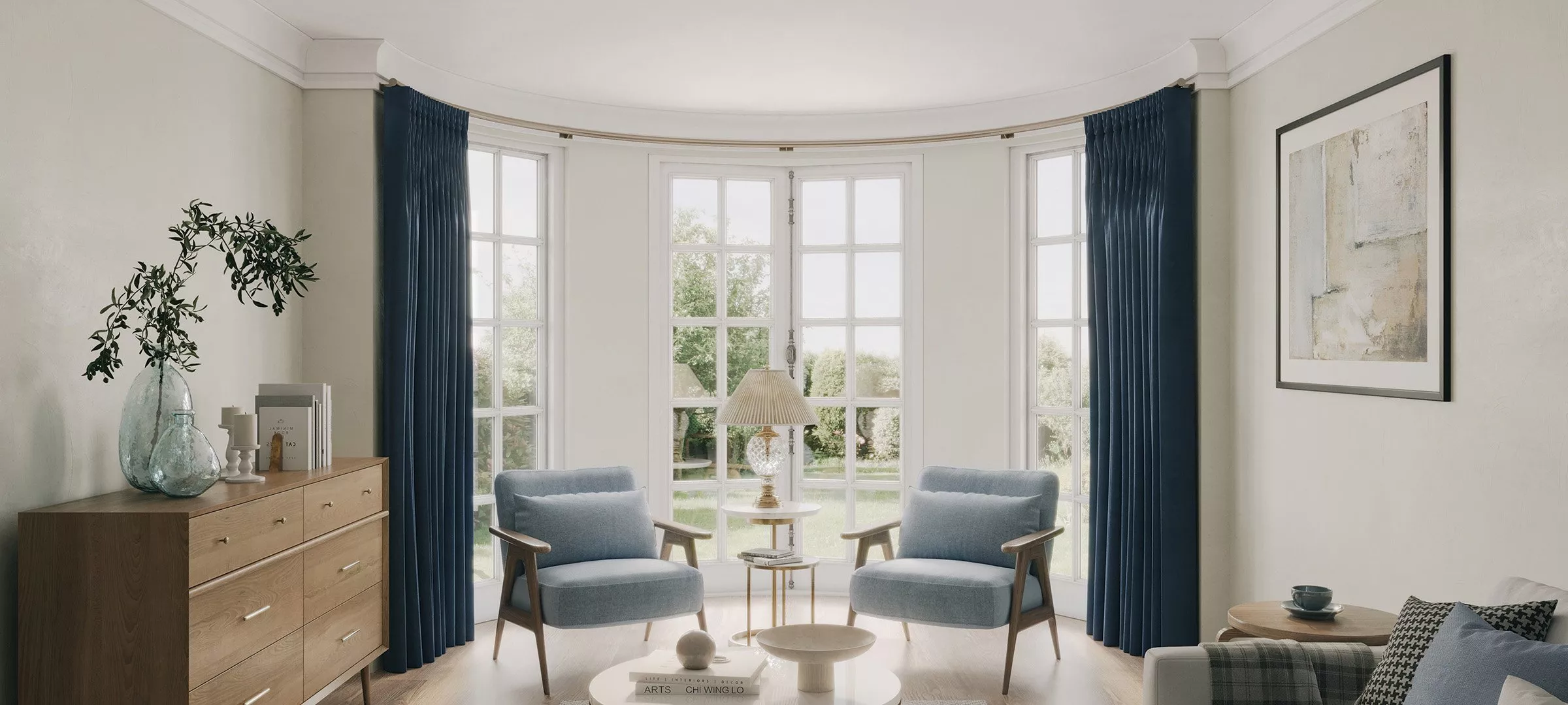 Living room setting with armchairs in front of a bay window and blue floor length curtains