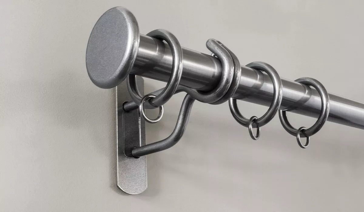Silver curtain pole attached the wall with a bracket