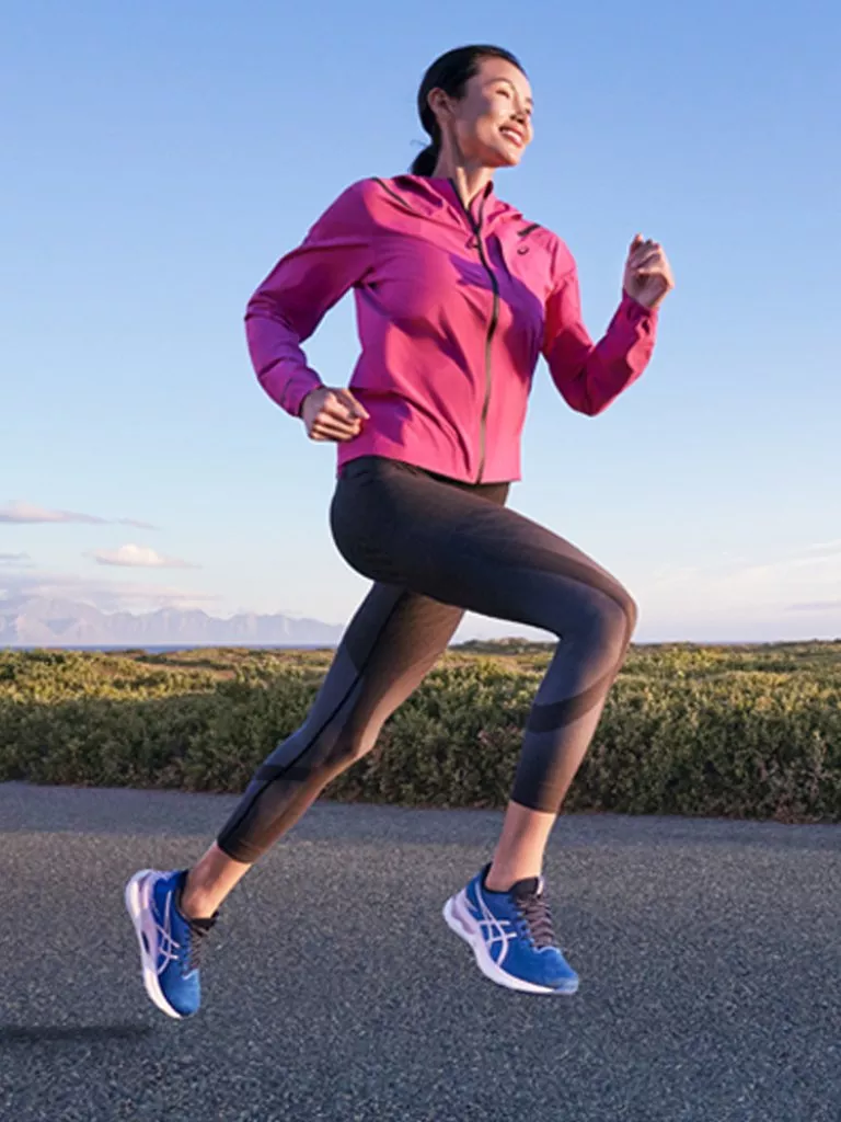 a running woman wearing a pink running jacket and black leggings