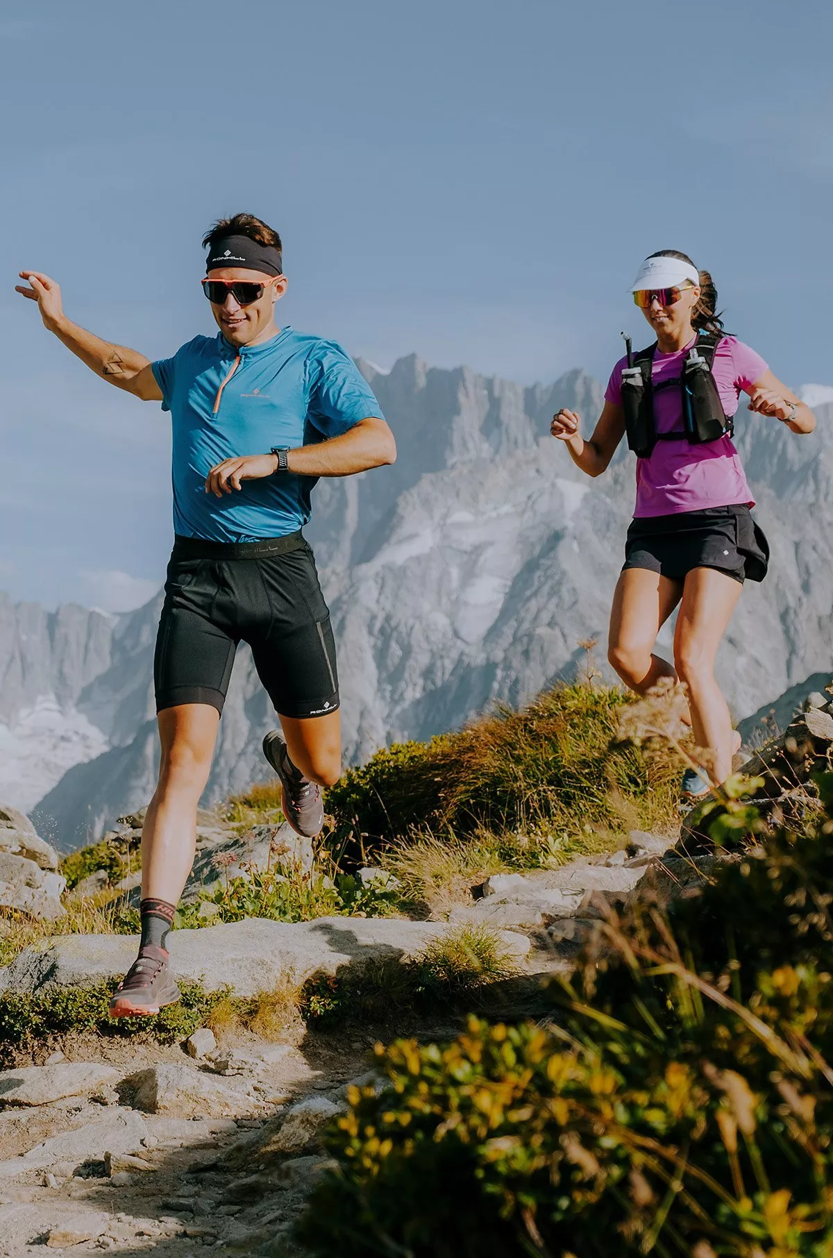 man in a blue t-shirt, black shorts and a woman in purple t-shirt, black shorts, out running